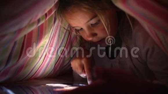晚上在床下盖看数字平板的女孩视频的预览图