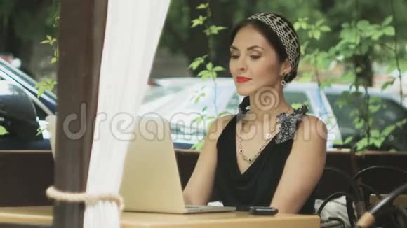 女人在咖啡馆里用手提电脑接电话有选择地集中注意力视频的预览图