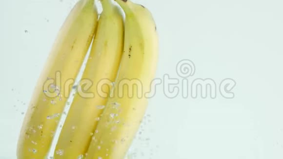 香蕉在白色背景下缓慢地浸入水中视频的预览图
