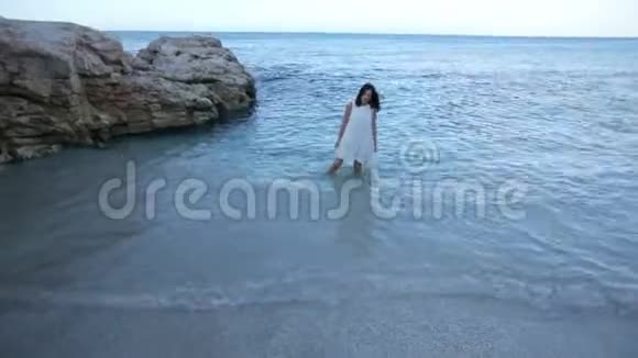 美丽的女孩穿着白色的裙子在海滨享受大海希腊视频的预览图