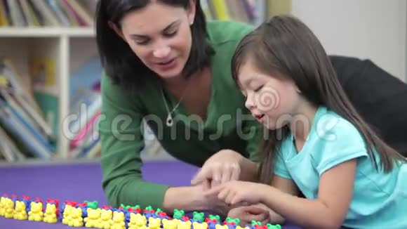 教师示范女孩如何计算塑料玩具视频的预览图