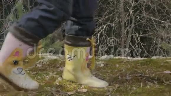 穿靴子的孩子在春天穿过树林fps96视频的预览图