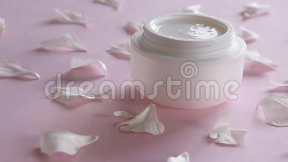 有机护肤品和粉色背景上娇嫩的花瓣健康化妆品视频的预览图