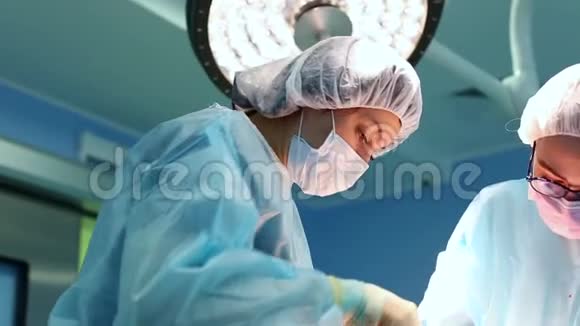 医生在工作一组专业外科医生对病人进行手术真正的手术室医学概念视频的预览图