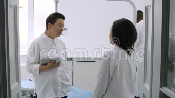 牙医在牙医诊所和年轻的女性病人交谈视频的预览图