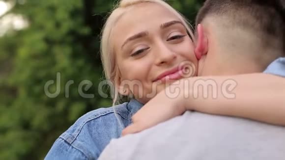 一个相爱的女孩拥抱她男朋友的肖像视频的预览图