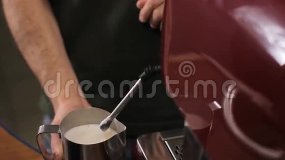 咖啡师把热气腾腾的牛奶煮成咖啡然后清理蒸汽手臂关门视频的预览图