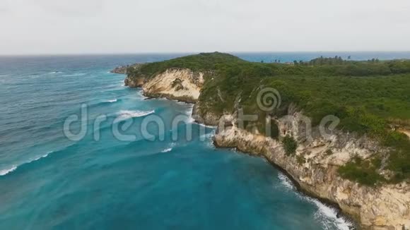 海浪拍打着长满草的岩石视频的预览图