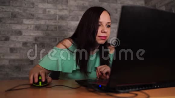 年轻女性使用笔记本电脑坐在白色砖墙背景前人和技术生活方式视频的预览图