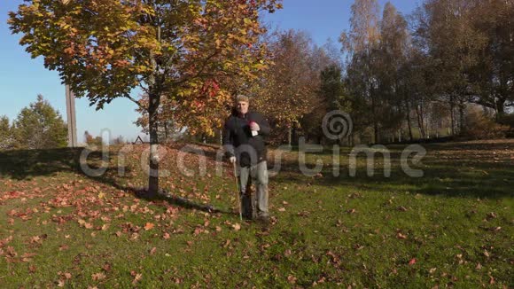 手拿拐杖的人喝咖啡在公园里散步视频的预览图