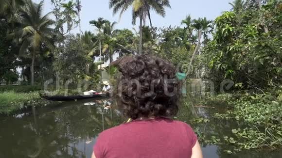 女人用独木舟探索喀拉拉的后水视频的预览图