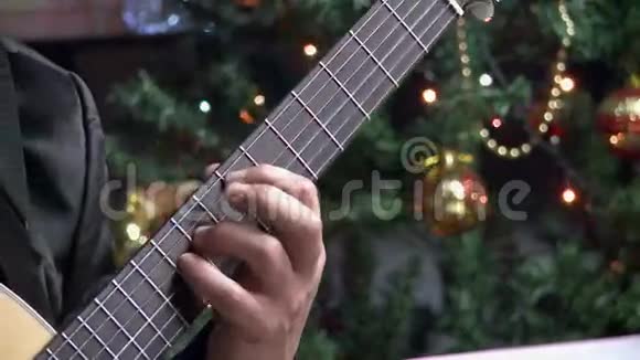 弹吉他特写在圣诞树上视频的预览图
