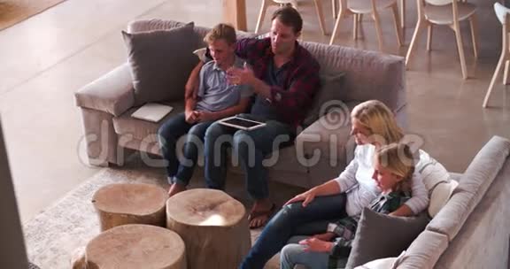 坐在沙发上看电视的家庭视野视频的预览图