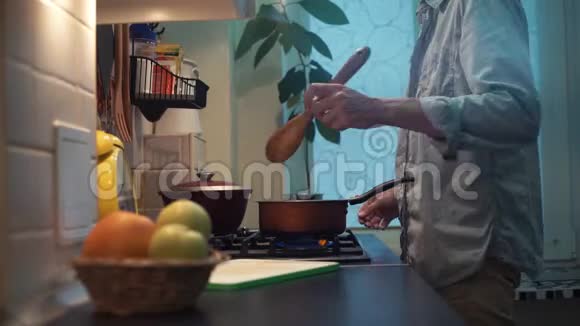 在厨房的炉子上用平底锅准备饭菜的人用木勺搅拌视频的预览图
