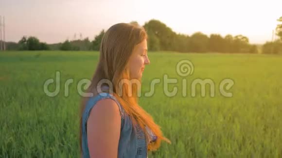 夕阳下一头直发的小女孩走在一片绿色的田野上平均射击视频的预览图