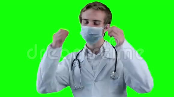 微笑医生移除医疗面罩看着屏幕视频的预览图