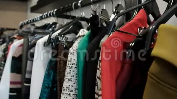 在商店里拍摄衣服用黑色衣架和连衣裙排成长队视频的预览图