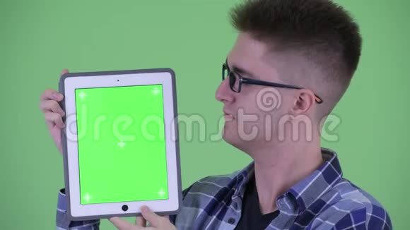 年轻快乐的时髦男人展示数码平板电脑视频的预览图