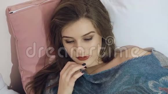 聪明的女孩放松躺在床上摆姿势慢慢地视频的预览图