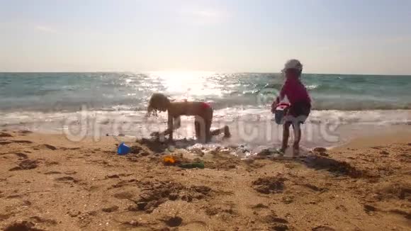 两个孩子在沙滩上玩沙子视频的预览图
