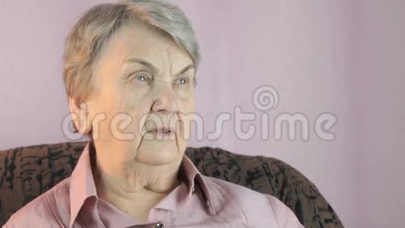 80多岁的老妇人坐在室内双手捂脸视频的预览图