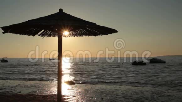 日落时的海滩伞视频的预览图