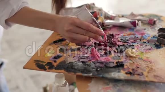 艺术家从调色板上的管子里挤出颜料视频的预览图