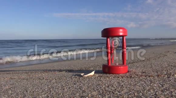 古老的红碎沙漏沙漏钟在沙滩上视频的预览图