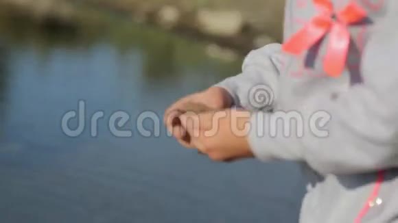 可爱的小女孩在岸上收集小石头视频的预览图