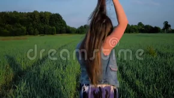 日落时分美丽的年轻女子在田野里跳舞视频的预览图
