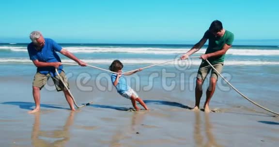 一家人在海滩玩拔河比赛视频的预览图