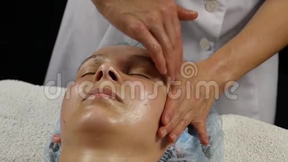 水疗沙龙塑料面部按摩妇女享受专业按摩治疗师的服务慢动作视频的预览图