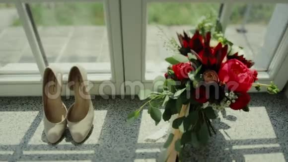 美丽的婚礼花束和新娘鞋靠近窗户视频的预览图
