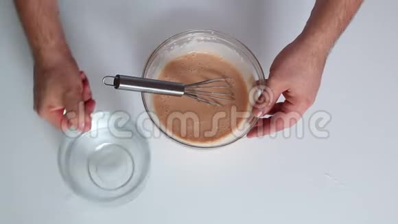 一个男人正在做古拉什酱用勺子把番茄酱和酸奶油放入玻璃容器中搅拌视频的预览图