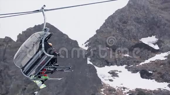 滑雪电梯与人们乘坐在雪山滑雪胜地下雪了滑雪板开放舱视频的预览图