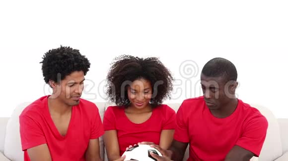 穿红衣服的球迷坐在沙发上拿球视频的预览图