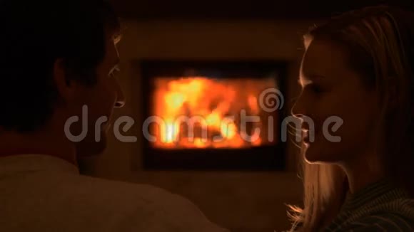 一对夫妇坐在壁炉旁的家里视频的预览图