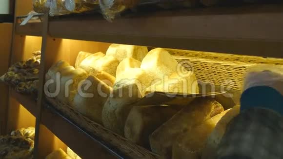 女人选择并把一个新鲜的面包放进超市的纸袋里视频的预览图