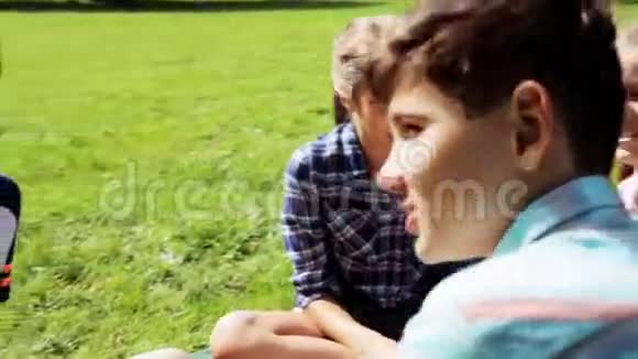 一群快乐的孩子坐在草地上聊天视频的预览图