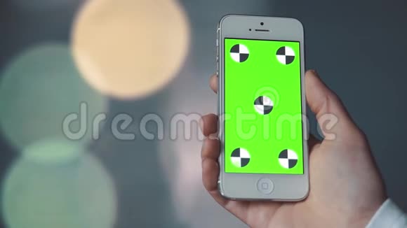 带有绿色屏幕的智能手机在bokeh背景前视频的预览图