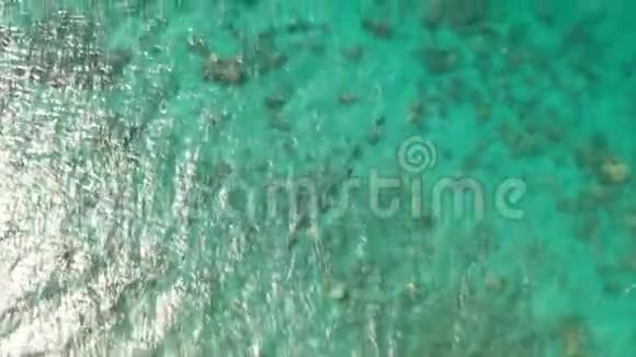 带珊瑚礁和太阳光的泻湖海面的鸟瞰图视频的预览图