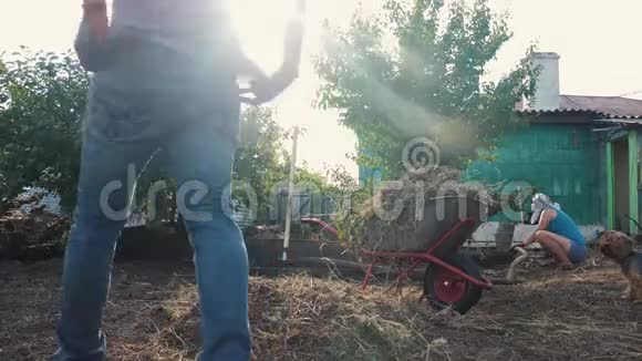 劳动男女园艺打扫草地园农业工作农民装载生活垃圾和草视频的预览图