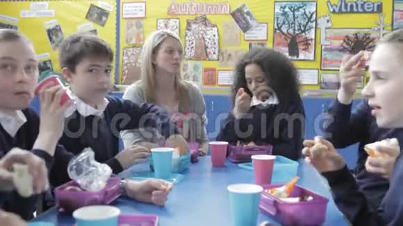 学童与老师一起享用午餐视频的预览图