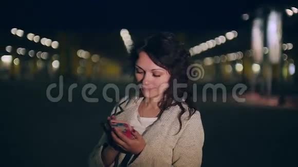 年轻女子在夜城的背景下打电话视频的预览图