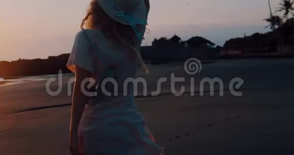 穿着连衣裙戴着帽子在热带海滩上轻松愉快视频的预览图