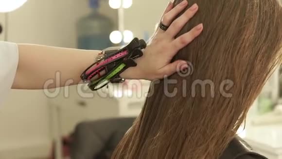 发型师在理发店给女性理发前梳理湿发在美容院贴出女性发型视频的预览图