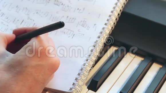 用铅笔把音乐家手中的笔记合上视频的预览图