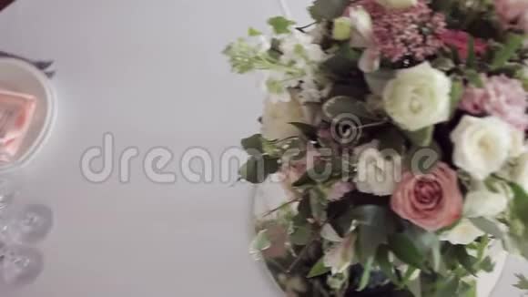 结婚花艺桌子上有漂亮的花束盘子和餐桌视频的预览图