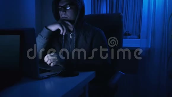 4K年轻人晚上用笔记本电脑工作的录像视频的预览图
