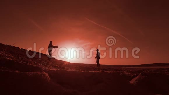排球两名男子在夕阳下沙滩上打排球剪影视频的预览图
